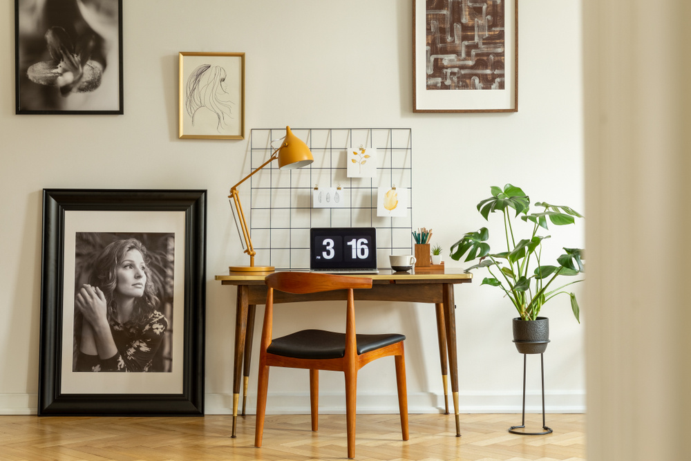 room with desk and artwork in various frames